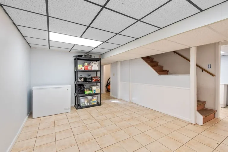 Finished basement with tile floor and storage shelves