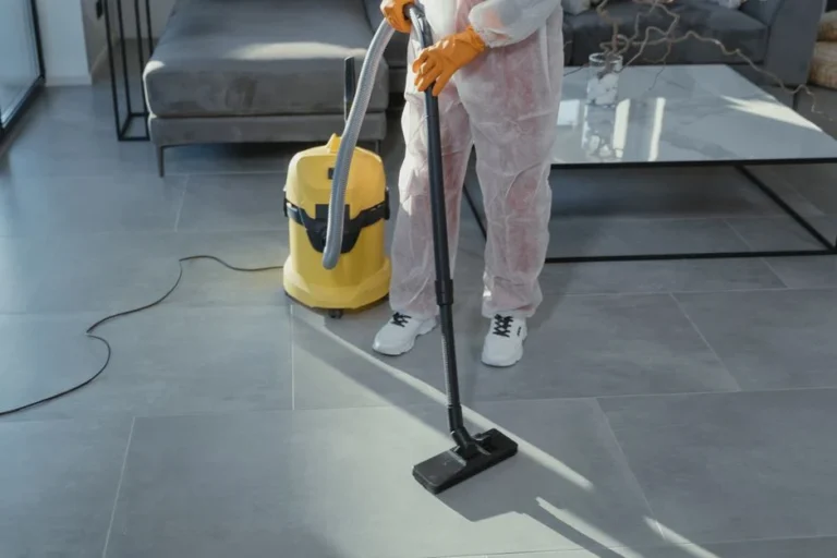 Restoration technician in protective gear extracting water from a floor